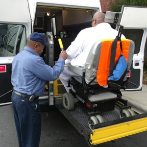 Dial-a-Ride driver helping a rider in wheelchair board the shuttle